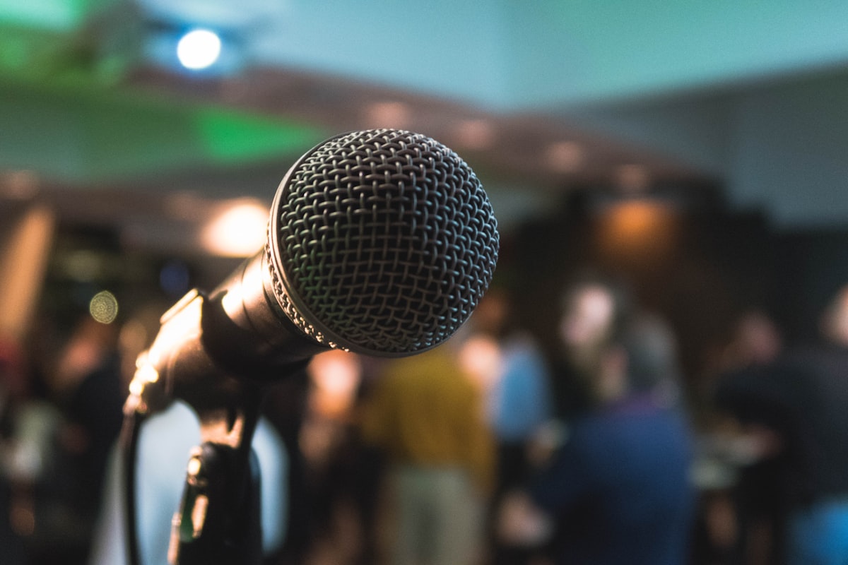 Generic stock photo of a brightly lit conference stage with an empty lectern, symbolizing a major AI policy announcement — not a photo of any real event or speaker