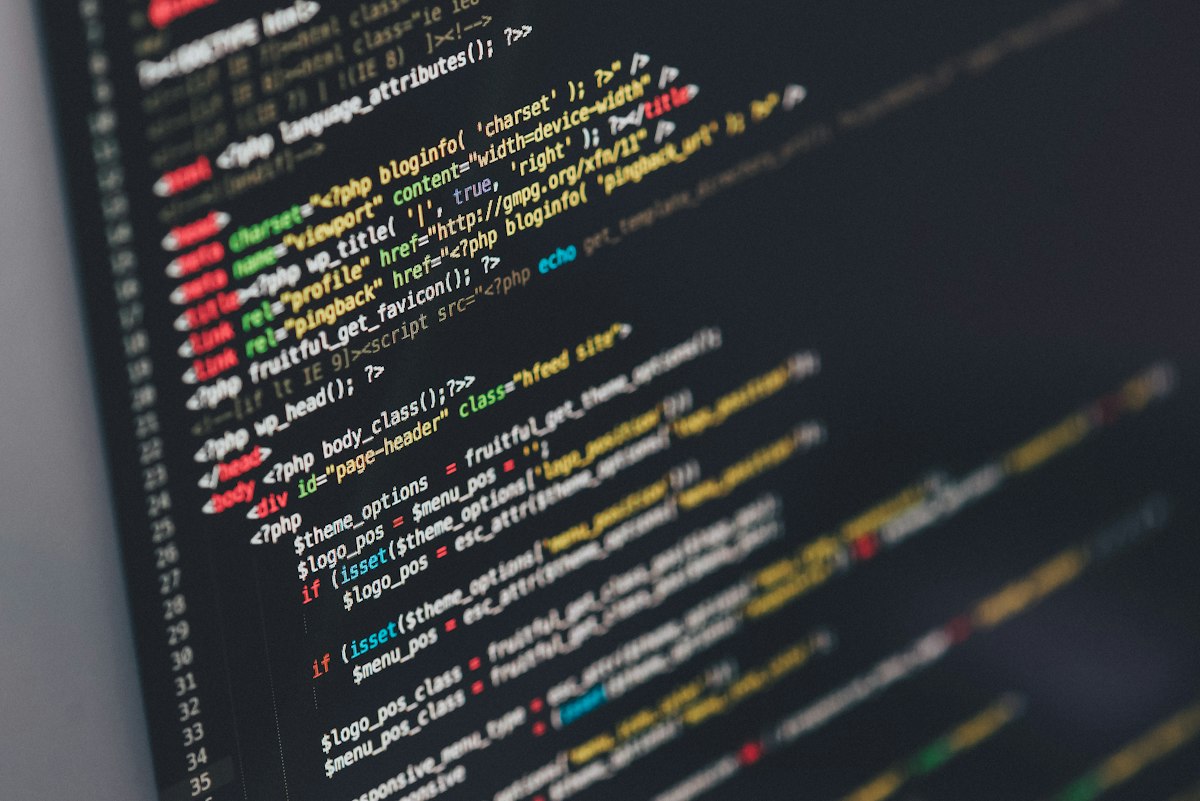 Source code on a computer monitor in a darkened room — generic stock photo illustrating self-hosting and the developer migration path from Deno to workerd described above, not an actual screenshot of the workerd runtime, celld, or any product UI