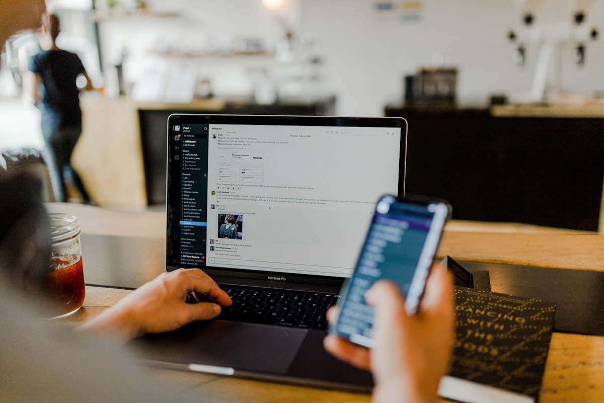 A person working on a laptop and phone in a cafe — a generic stock photo, not an actual disclosure timeline graphic