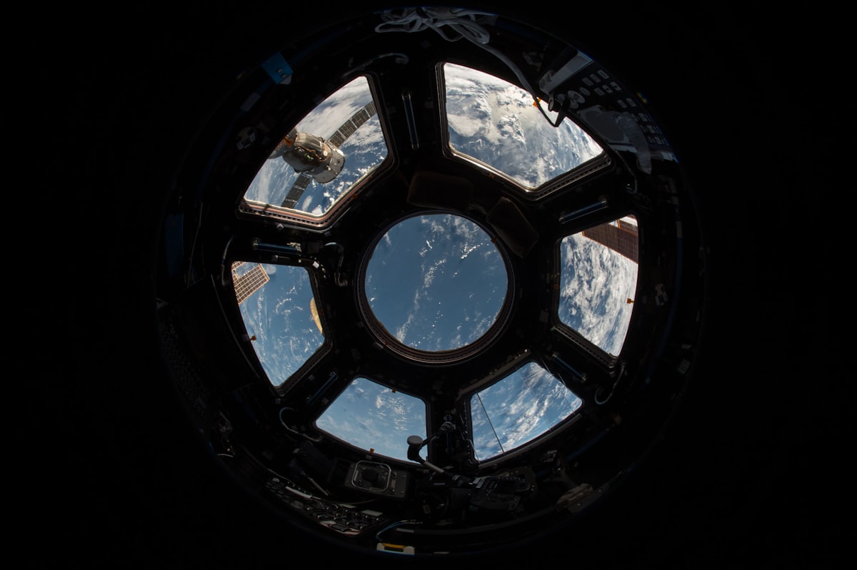 Satellite orbiting above the curved limb of Earth with solar panels extended — generic stock photo used to illustrate the Project Suncatcher prototype discussed in this post, not an actual photograph of the mission or its TPUs
