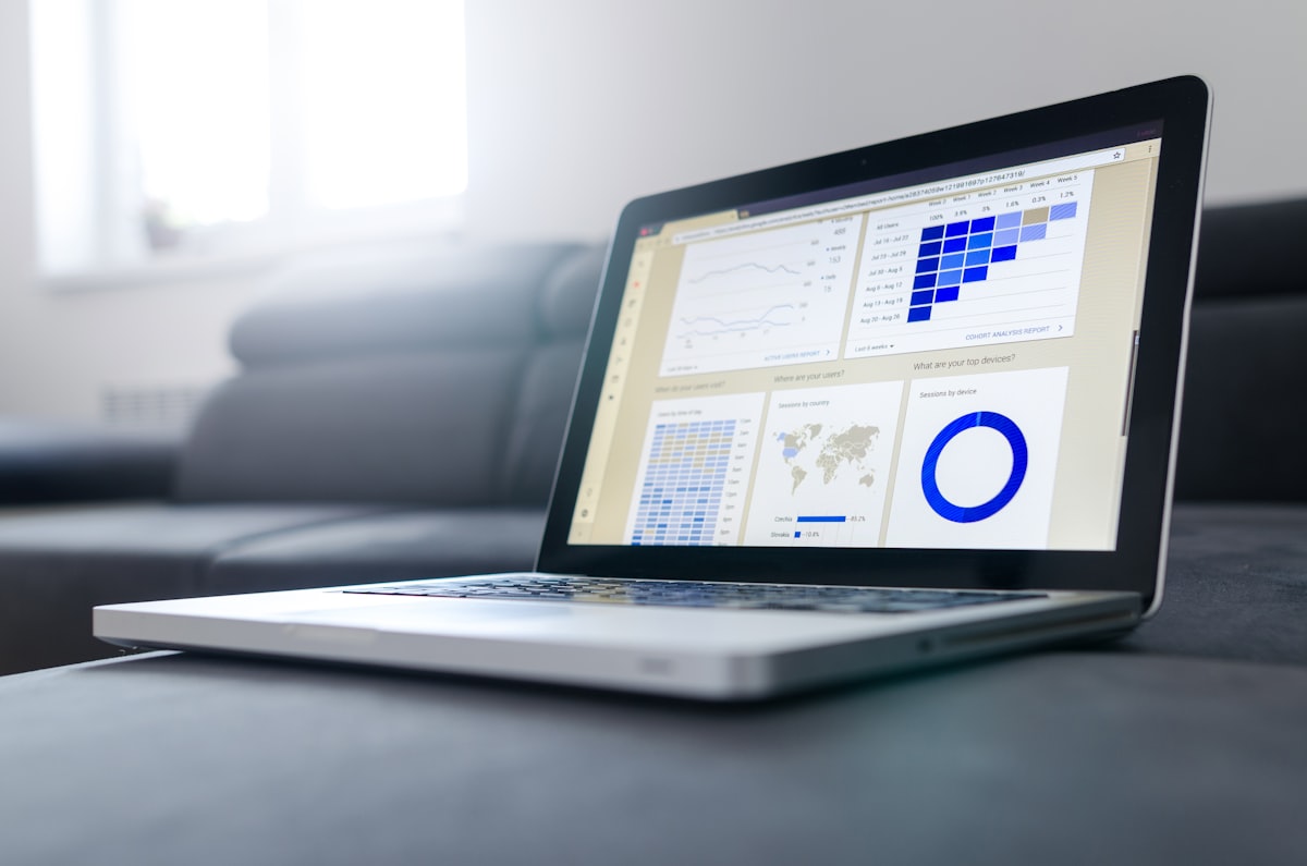 Stock photo of a laptop on a desk displaying a generic analytics report with charts and a donut graph — illustrative only, not actual benchmark results